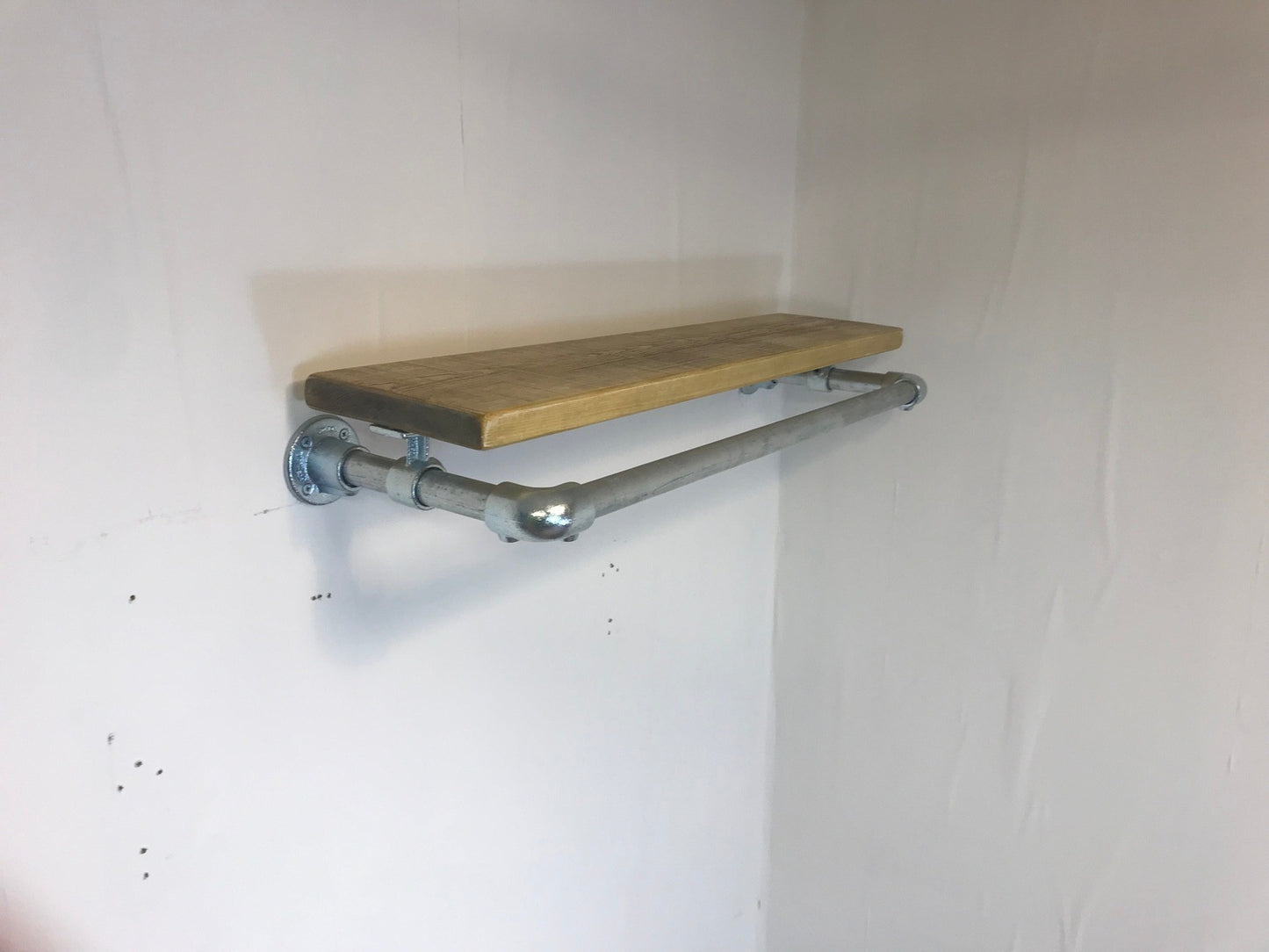 Wall fixed clothing rail with wood shelf in various widths. Black or galvanised silver.